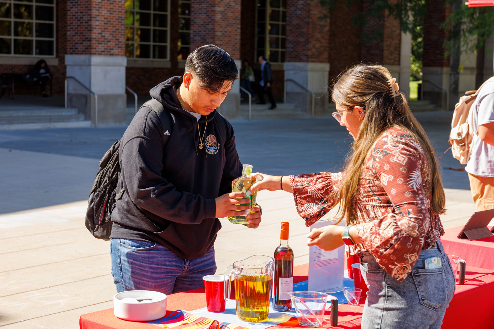 Well-being Ambassador explains alcohol by volume to help student know how to pour a typical drink