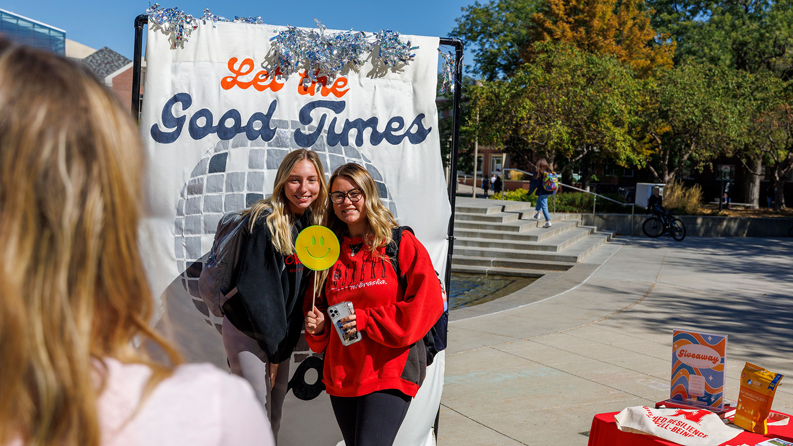 Students stand in front of Let The Good Times Roll photo banner during an alcohol education event on the Nebraska Union plaza