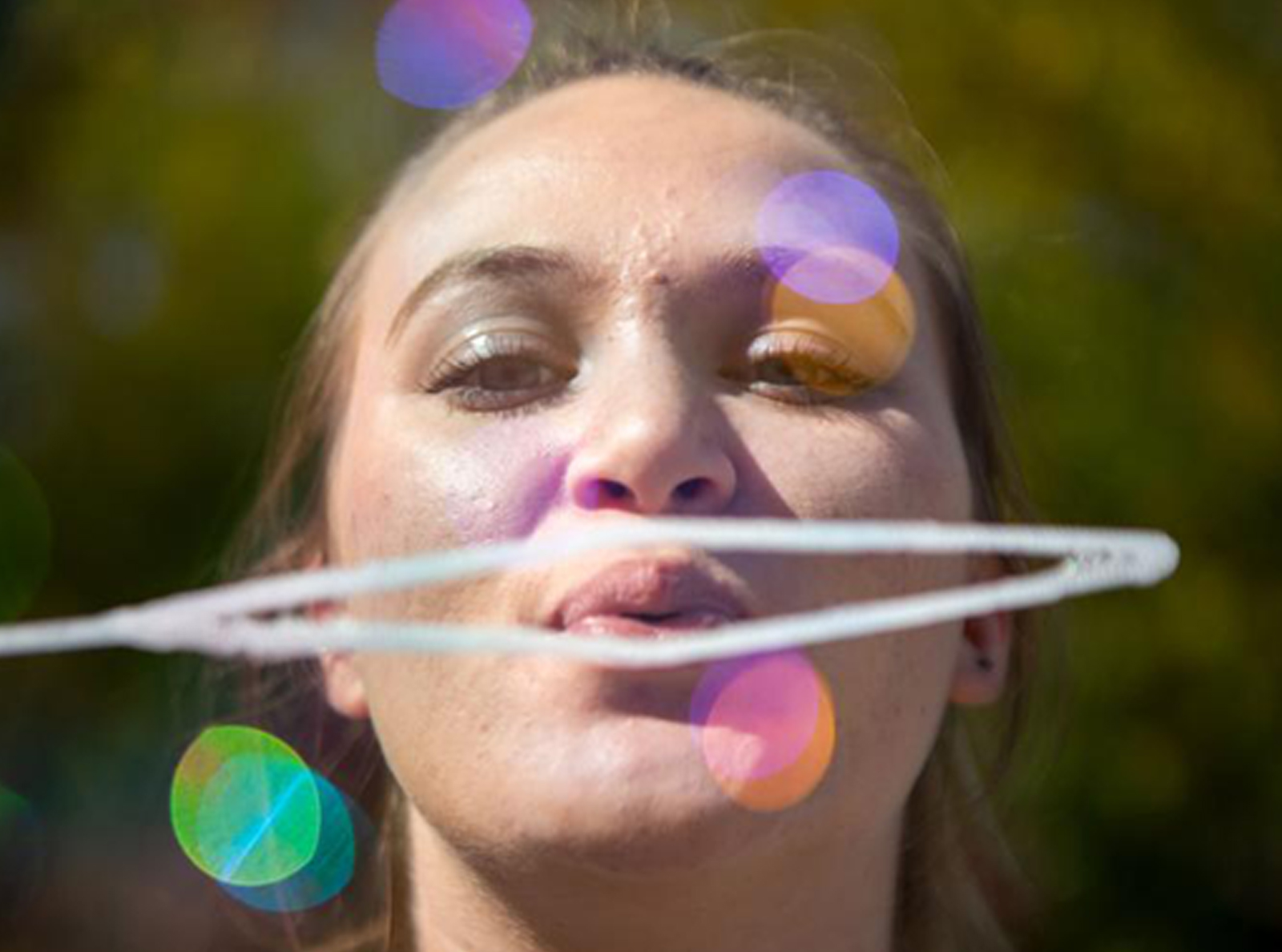 Woman blowing bubbles at recess