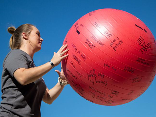 Woman catching a ball covered with written phrases at recess